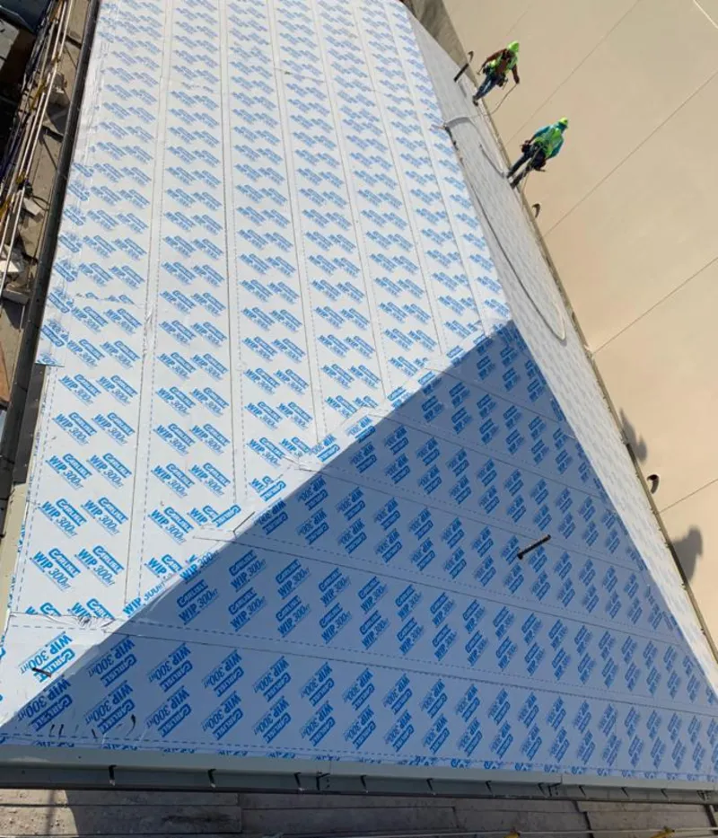 Professional roofers installing underlayment on a metal roof in Denver